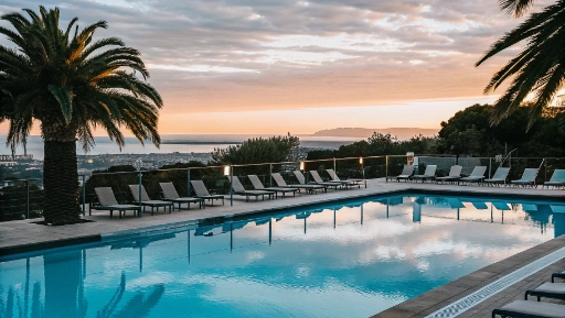 Hotel pool terrace with loungers overlooking Terracina coastline at golden hour